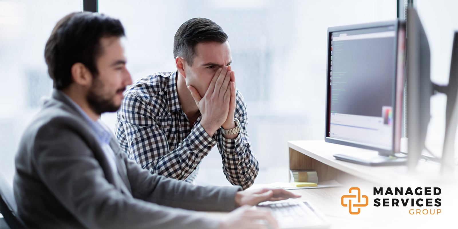 Managed Services Group - Two men working at desk computer