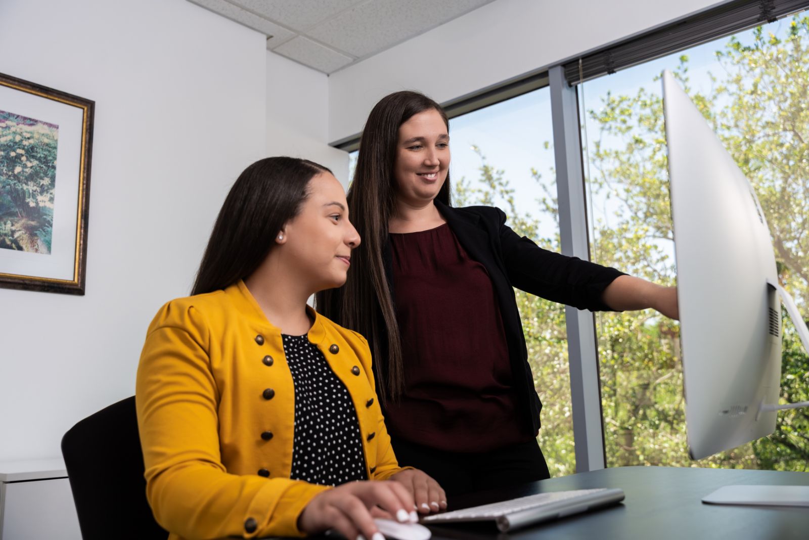 team member pointing out computer content to colleague